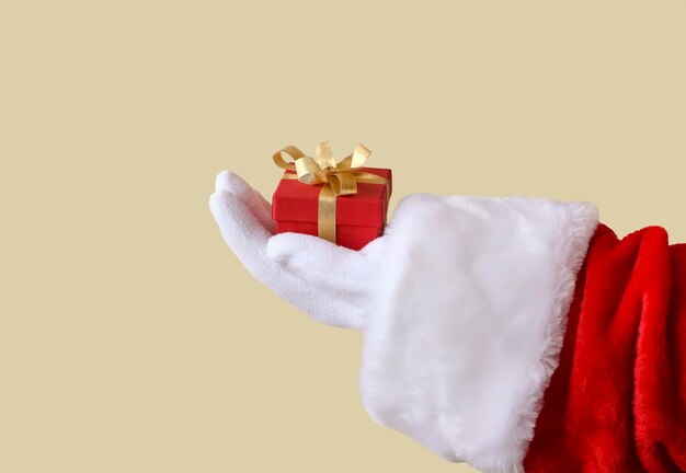 La mano de Santa Claus sostiene un regalo de Navidad