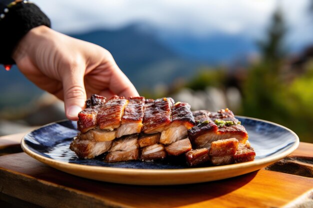 Foto mano sirviendo panceta de cerdo a la parrilla en un plato de cerámica