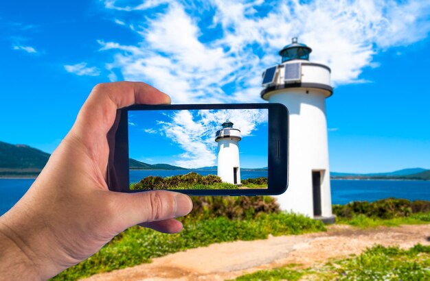 Mano con smartphone tomando fotos en un día soleado