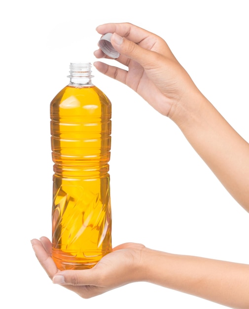 Mano sosteniendo aceite vegetal para cocinar en una botella aislada sobre fondo blanco