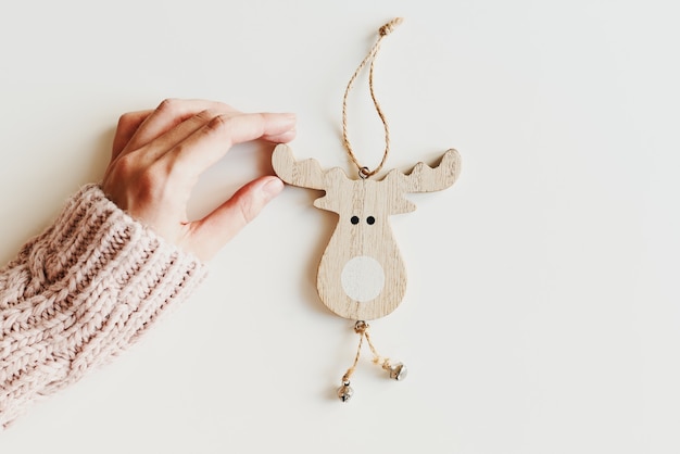 Mano sosteniendo un adorno de Navidad Decoración de árbol de Navidad de madera