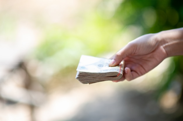 Foto mano sosteniendo un alijo de dinero