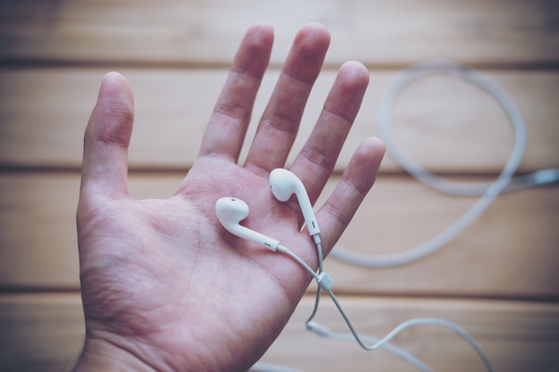 Foto mano sosteniendo auriculares