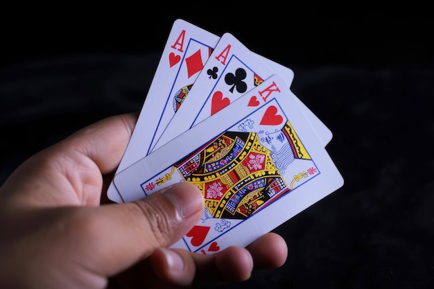 Una mano sosteniendo una baraja de cartas con el Rey de Corazones en el medio