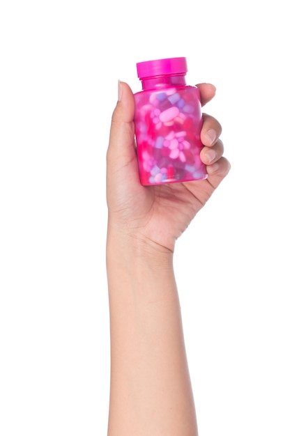 mano sosteniendo una botella de medicina con tabletas de pastillas dentro aisladas sobre fondo blanco pastillas derramándose de una botella de plástico aislada sobre fondo blanco