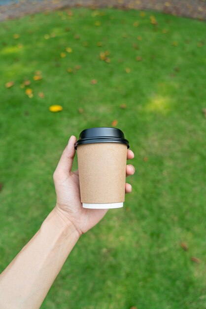 mano sosteniendo café caliente en vaso para llevar