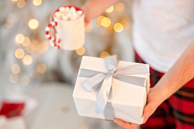 mano sosteniendo una caja blanca con regalo