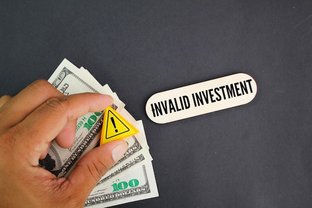 Una mano sosteniendo un cartel que dice factura en el medio que dice inversión no válida.