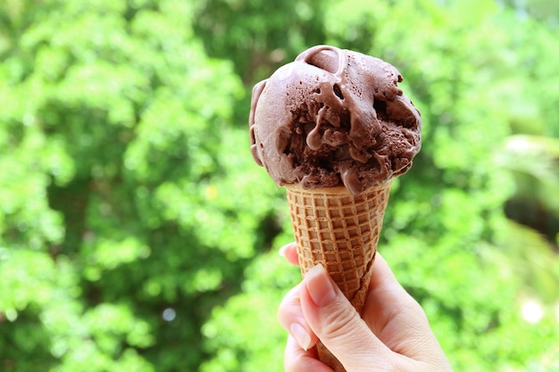 Mano sosteniendo un cono de helado de chispas de chocolate