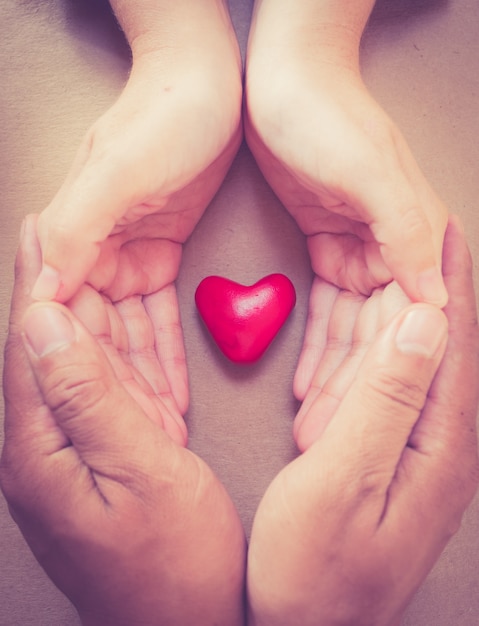 mano sosteniendo un corazón rojo