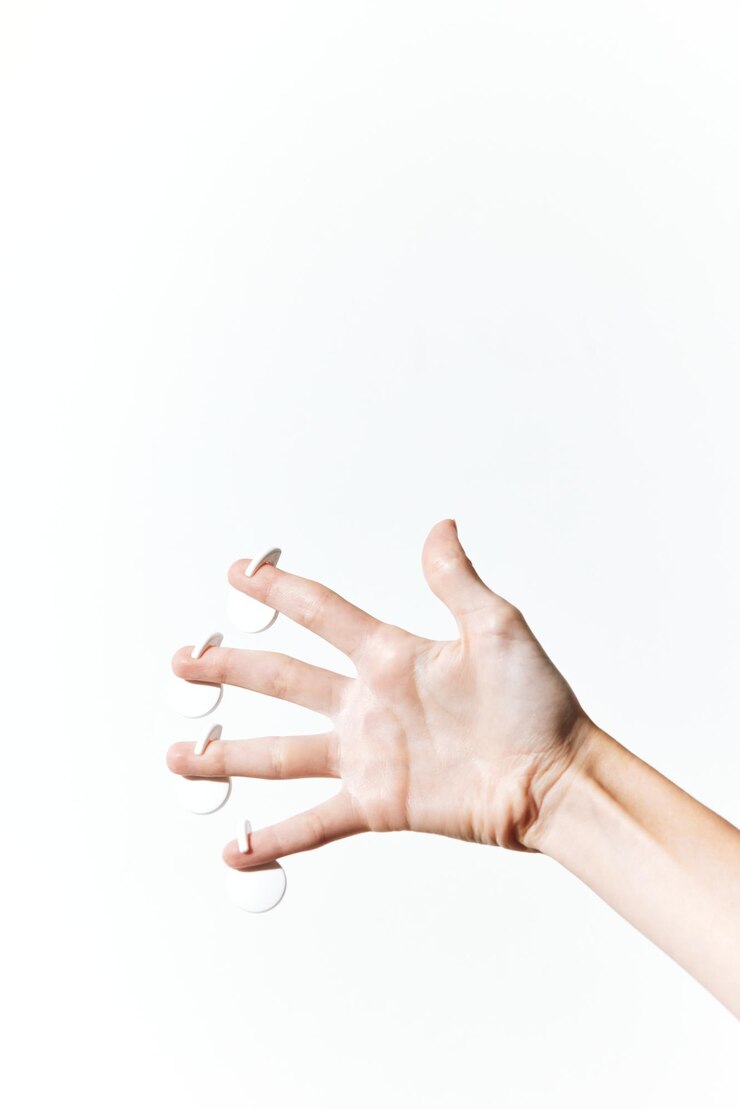 Foto la mano sosteniendo cortadoras de uñas blancas en un fondo blanco los dedos extendidos