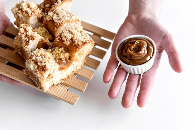 Mano sosteniendo cuca brasileña tradicional rellena con dulce de leche