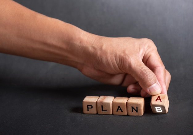 Mano sosteniendo dados con texto para ilustración de palabras PLAN A PALAN B