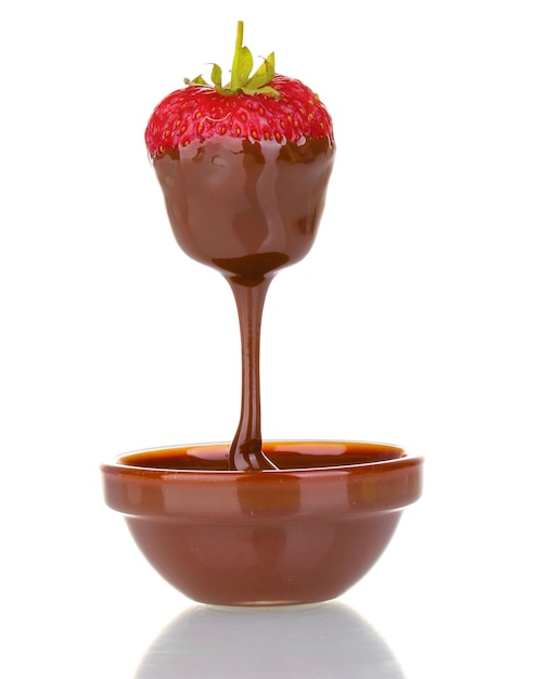 Mano sosteniendo fresa en chocolate aislado en blanco