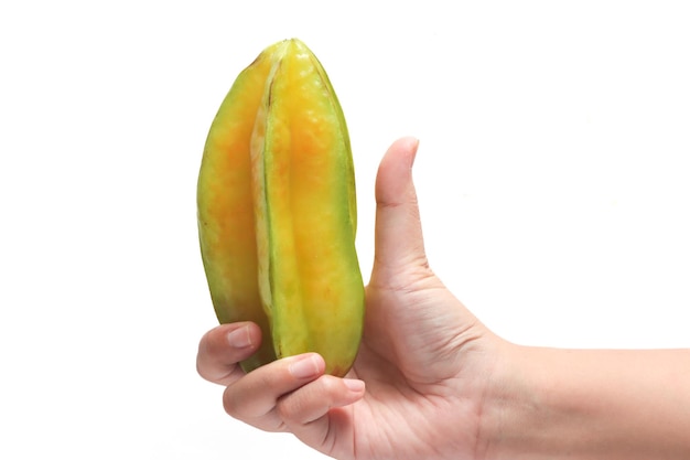 La mano sosteniendo frutas de estrella orgánicas frescas deliciosas con el dedo pulgar aislado sobre fondo blanco