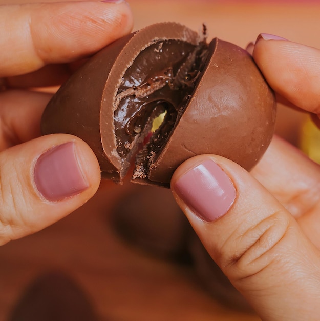 Una mano sosteniendo un huevo de chocolate al que se le quitó el interior.