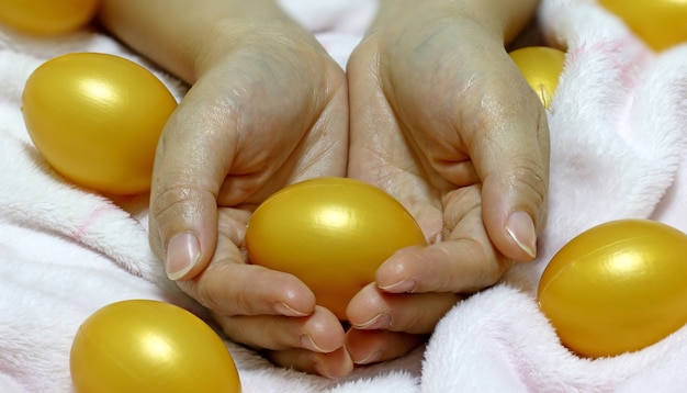 mano sosteniendo huevos de oro para Semana Santa