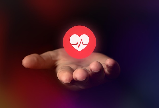 Mano sosteniendo el icono del corazón. Fondo de salud y cardiología, concepto de análisis de datos médicos.