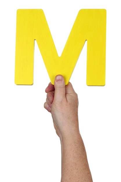 Mano sosteniendo la letra M del alfabeto