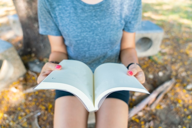 Mano sosteniendo un libro en el jardín