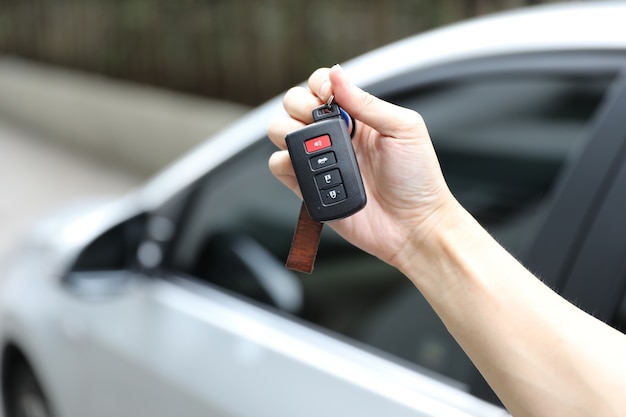 mano sosteniendo la llave del coche con el fondo del coche