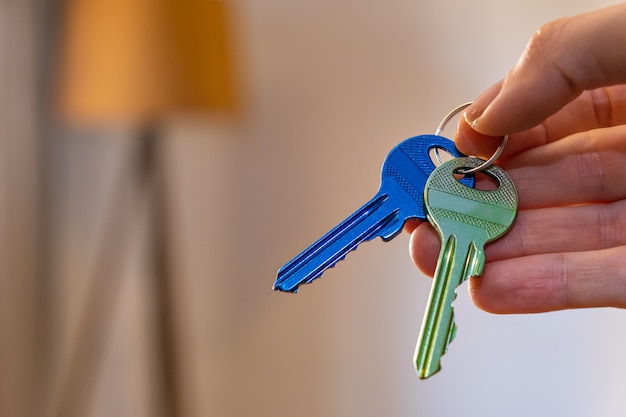 Mano sosteniendo las llaves con habitación en el fondo alquiler vender comprar apartamento negocio inmobiliario