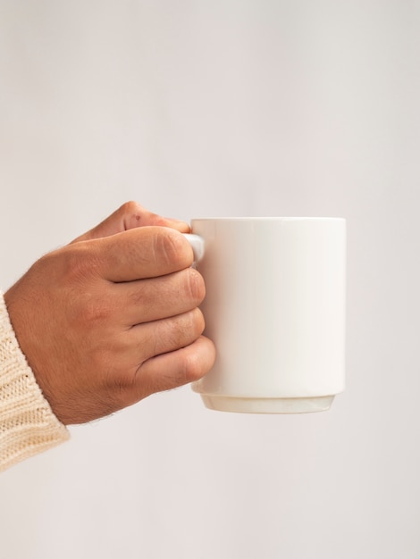 Foto mano sosteniendo una maqueta de taza