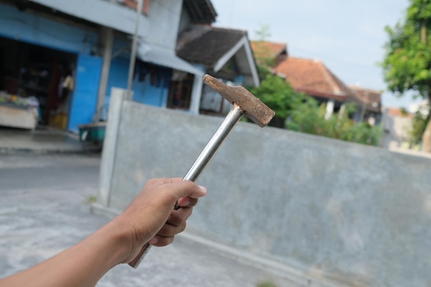 Una mano sosteniendo un martillo con la palabra martillo