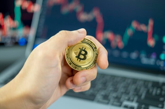 mano sosteniendo una moneda criptomoneda bitcoin en el fondo del gráfico concepto de criptomoneda virtual criptomoneda digital para defi banca financiera descentralizada tecnología de inversión de intercambio p2p