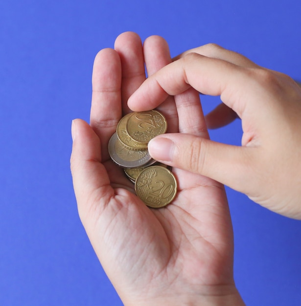 Foto mano sosteniendo monedas de euro