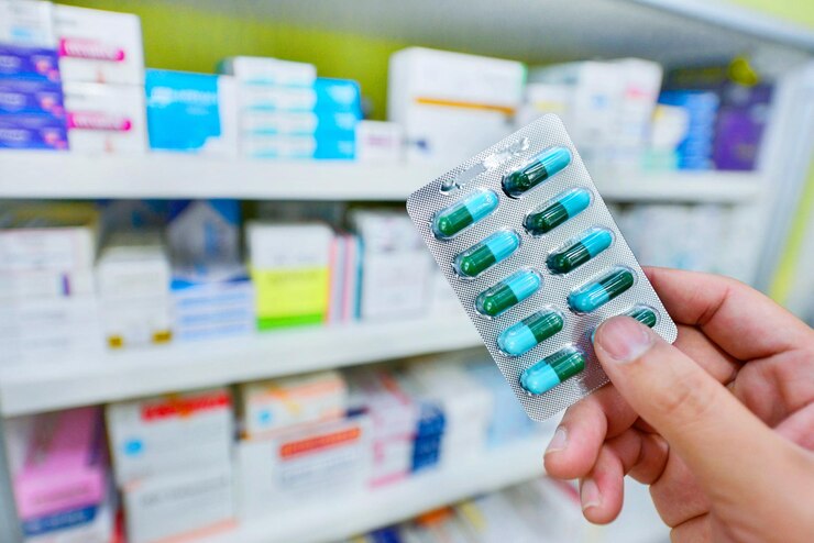 Foto mano sosteniendo el paquete de cápsulas de medicina en la farmacia