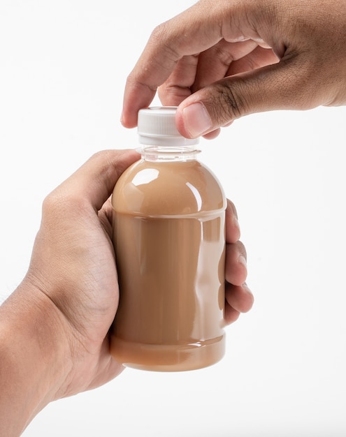 Mano sosteniendo el producto de botella de plástico