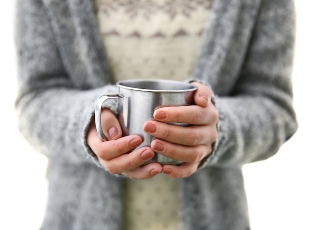 Mano sosteniendo la taza de café, al aire libre