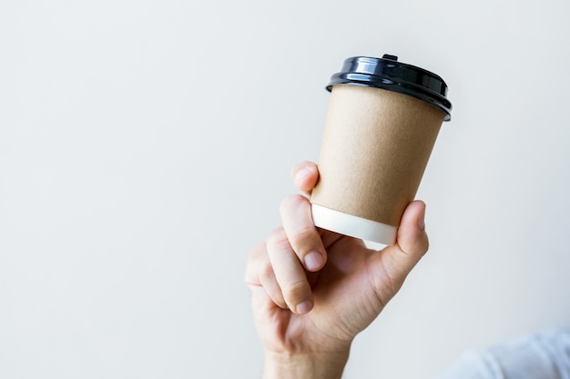 Mano sosteniendo una taza de café caliente