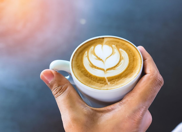 Mano sosteniendo una taza de café con leche Día internacional del café