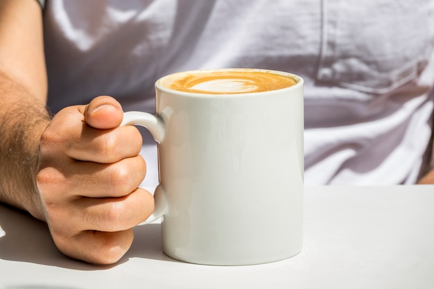 Mano sosteniendo taza de café