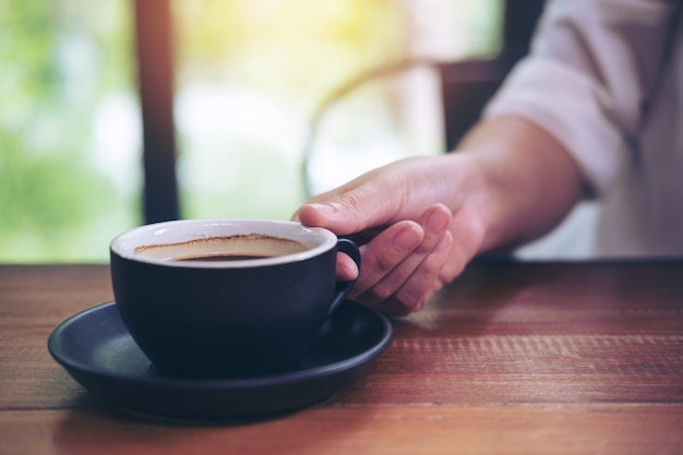 mano sosteniendo la taza de café