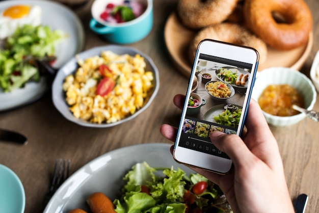 Mano sosteniendo teléfono móvil Foto de comida rápida