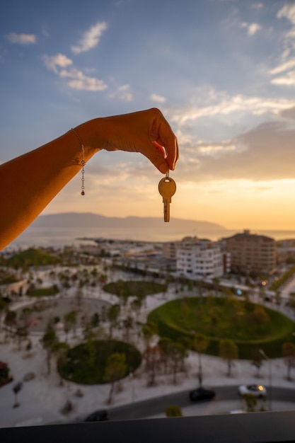 Mano sosteniendo tres llaves sobre la mano en el fondo del atardecer Concepto de construcción