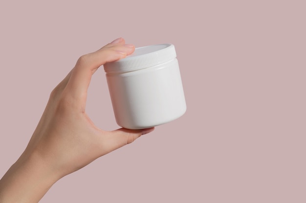 Mano sosteniendo un tubo de plástico blanco en blanco Maqueta de marca de producto de belleza cosmética Espacio de copia