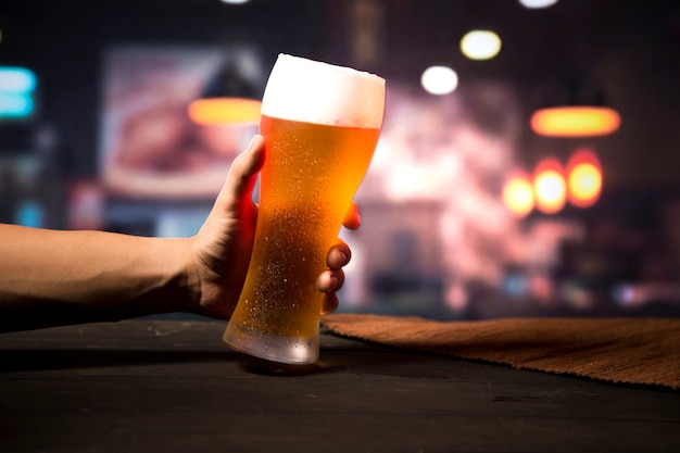 Foto mano sosteniendo vaso de cerveza