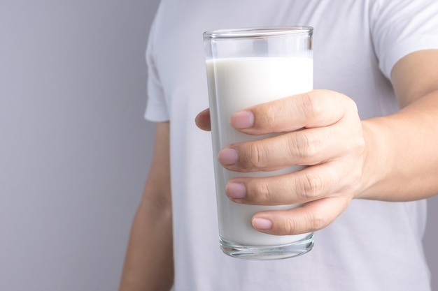 Mano sosteniendo un vaso de leche fresca