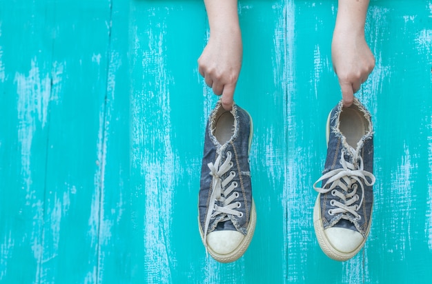 Foto mano sosteniendo un zapato sucio