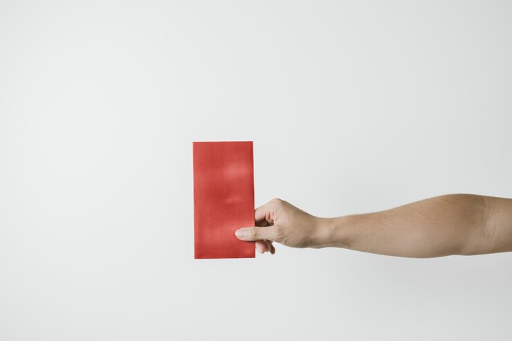 Una mano sostiene angpao o regalo monetario rojo en fondo blanco concepto de Año Nuevo Chino Gong Xi Fa Cai