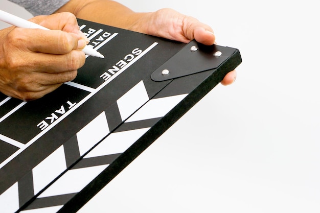 Foto la mano sostiene claqueta o pizarra de película color negro y rotulador concepto de industria cinematográfica