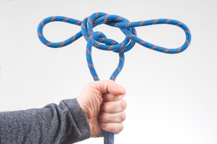 Foto la mano sostiene la cuerda de color para el artículo del equipo de escalada para acampar y escalar