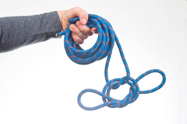 Foto la mano sostiene la cuerda de color para el artículo del equipo de escalada para acampar y escalar