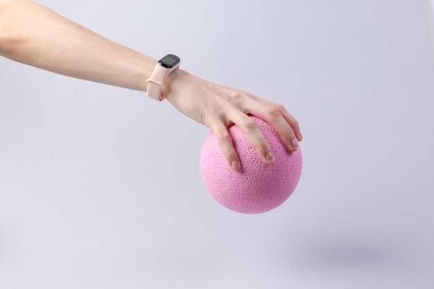 Foto la mano sostiene un globo rosa sobre un fondo gris minimalismo concepto de idea fresca