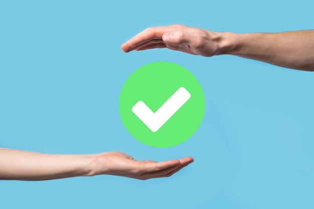 La mano sostiene el icono verde Marca de verificación, signo de marca de verificación, icono de marca, signo derecho, botón de marca de verificación verde circular, Listo. Sobre fondo oscuro. Banner. Espacio de copia. Lugar para el texto.