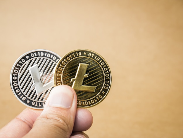 Foto la mano sostiene litecoin de oro y plata.